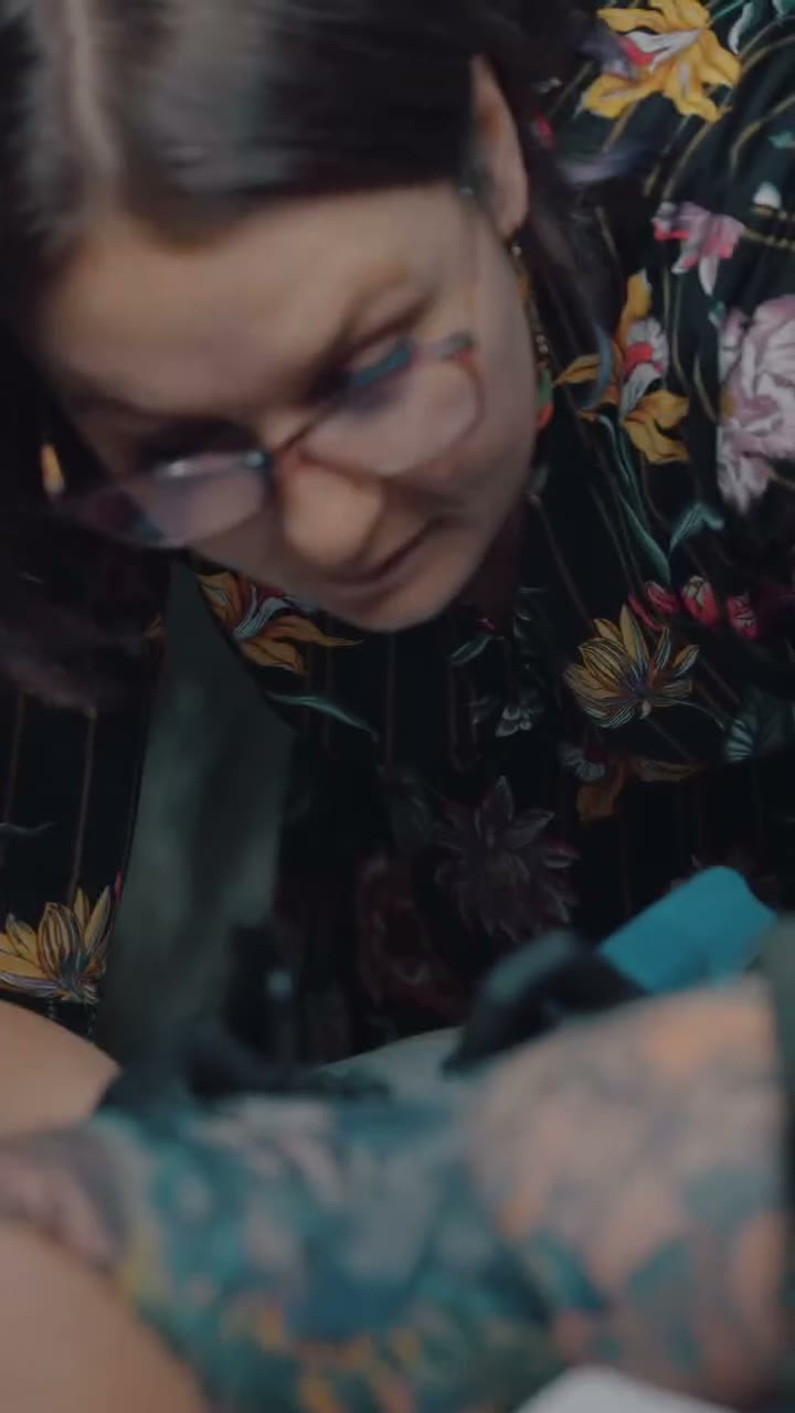 Film z pracowni tatuażu: Ewa przerabia tatuaż Rafała, a kamera zagląda w detal pracy i wnętrze studia.